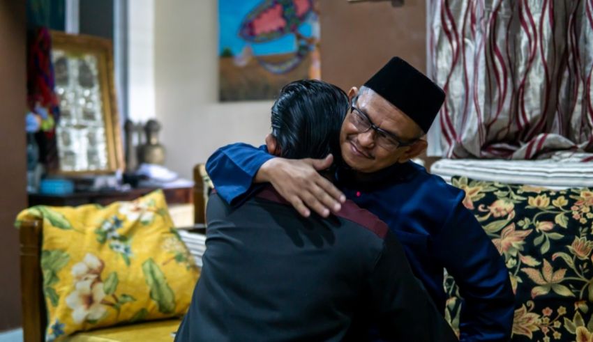 Two men hugging each other in a living room.