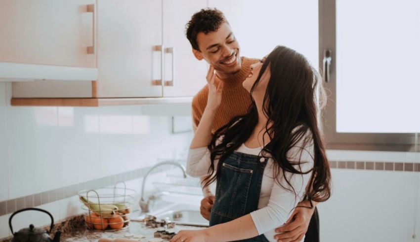 A couple in a kitchen embracing each other.