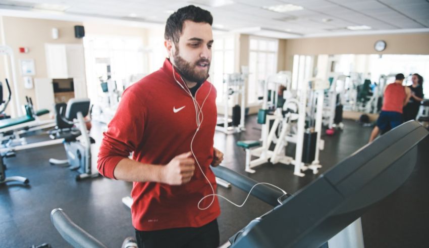 A man jogging on a treadmill in a gym.