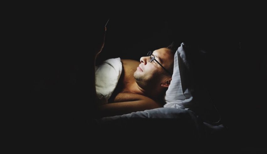 A man laying in bed in the dark.