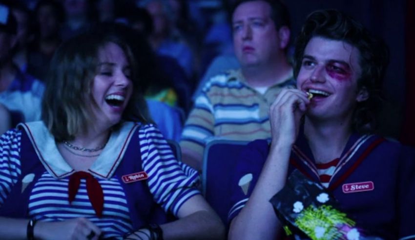 Two people laughing in a movie theater.