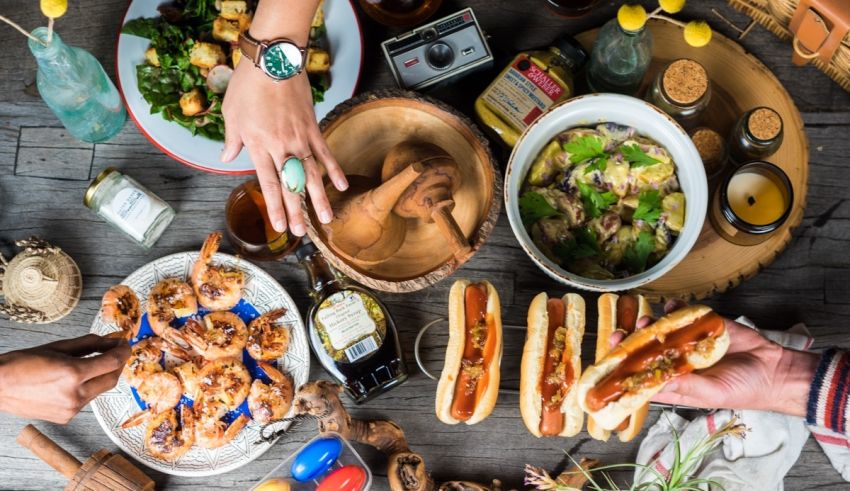 A group of people eating food on a wooden table.