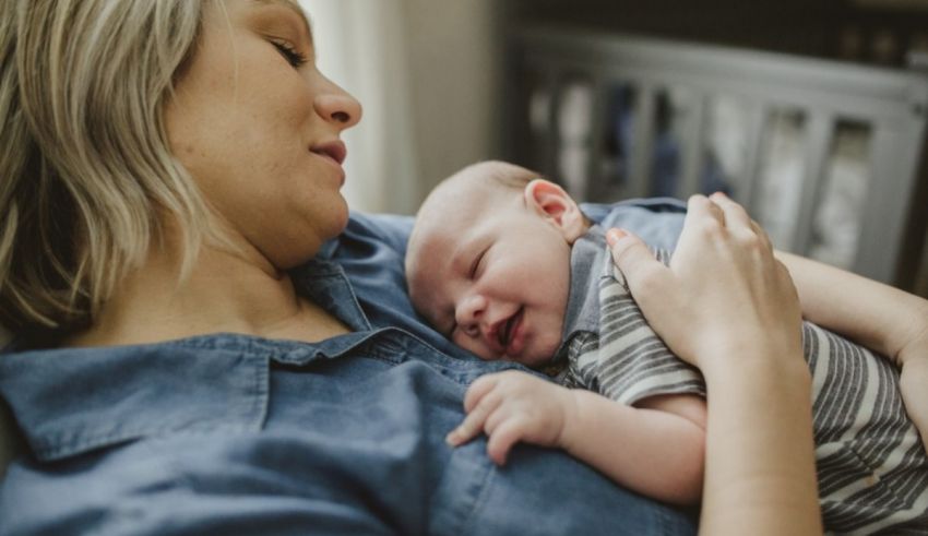 A woman is holding her baby in her arms.