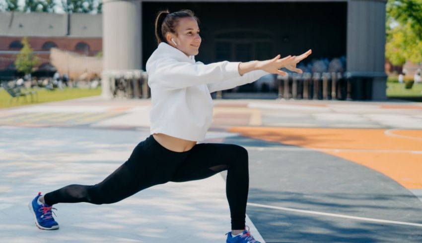 A young woman doing a squat on a basketball court.