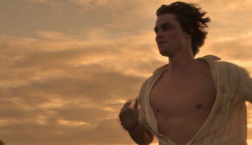 A man in a white shirt running at sunset.