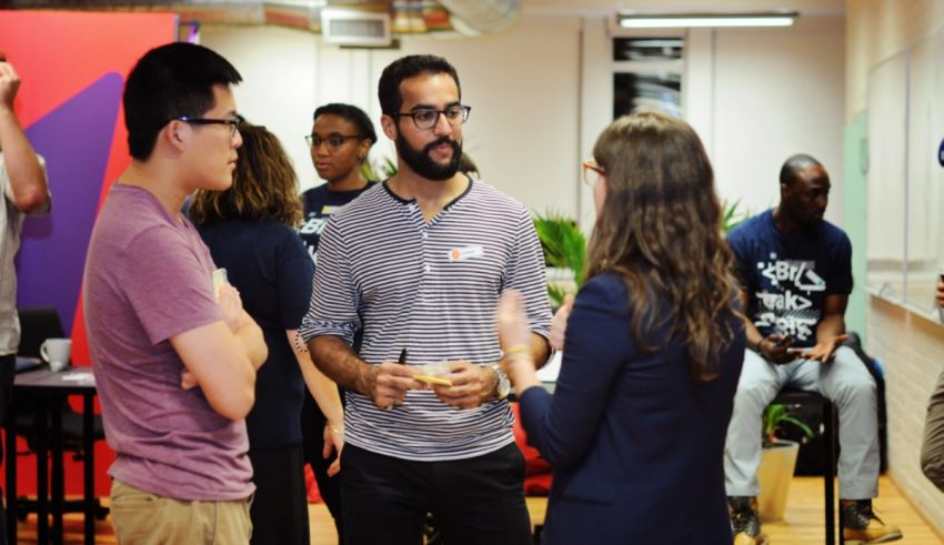 A group of people talking in an office.