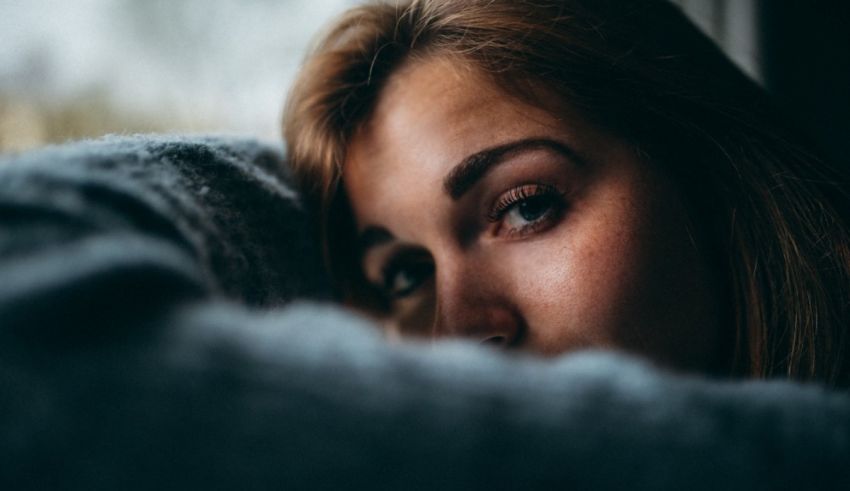 A woman is staring out of a window.