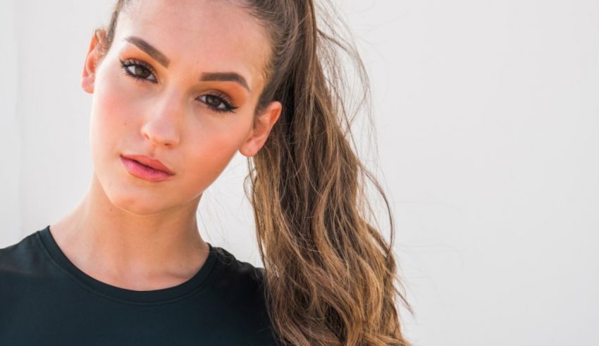 A young woman wearing a black top with a ponytail.