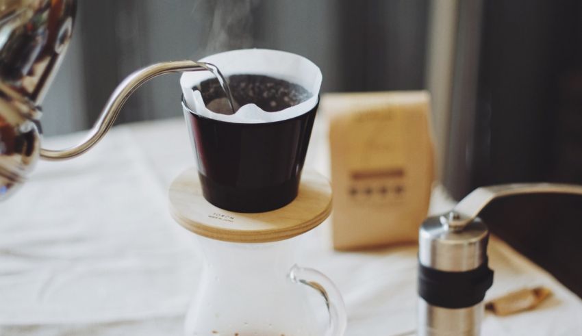 Coffee being poured into a glass on a table.