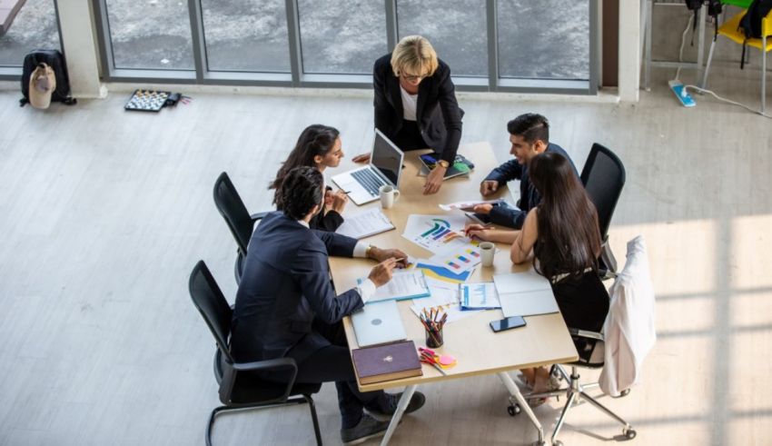 A group of business people sitting around a table in an office.