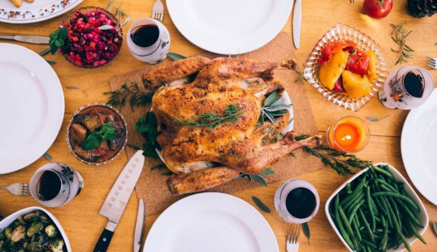 Thanksgiving dinner on a table with a turkey, green beans, and cranberry sauce.