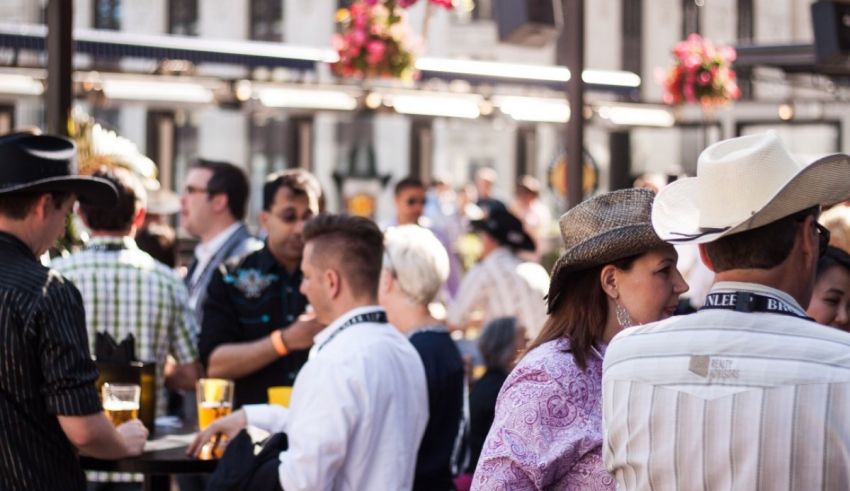 A group of people wearing cowboy hats at an outdoor event.