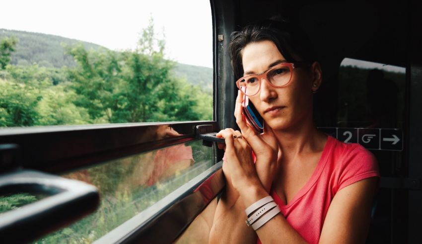 A woman on a train talking on her cell phone.