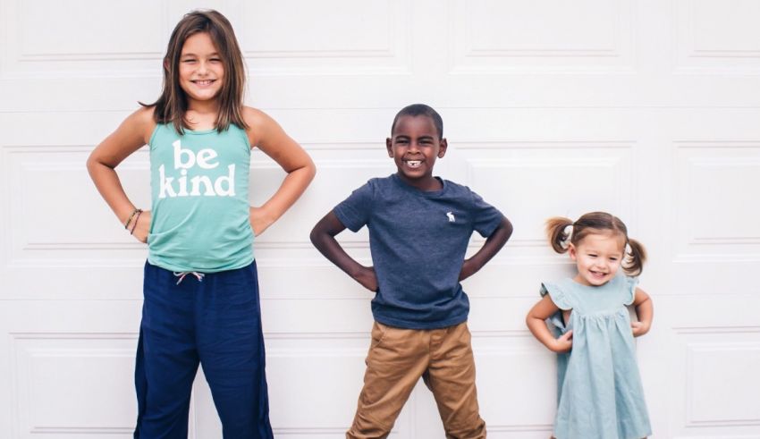 Three children posing in front of a garage door.