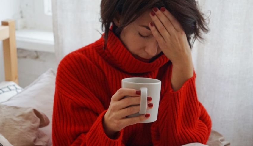 A woman in a red sweater holding a coffee mug.