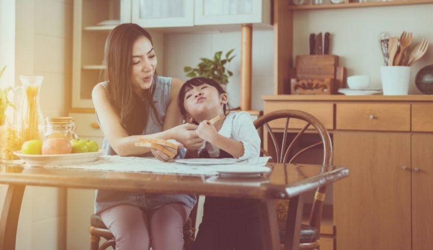 A mother and child sitting at a table in the kitchen.