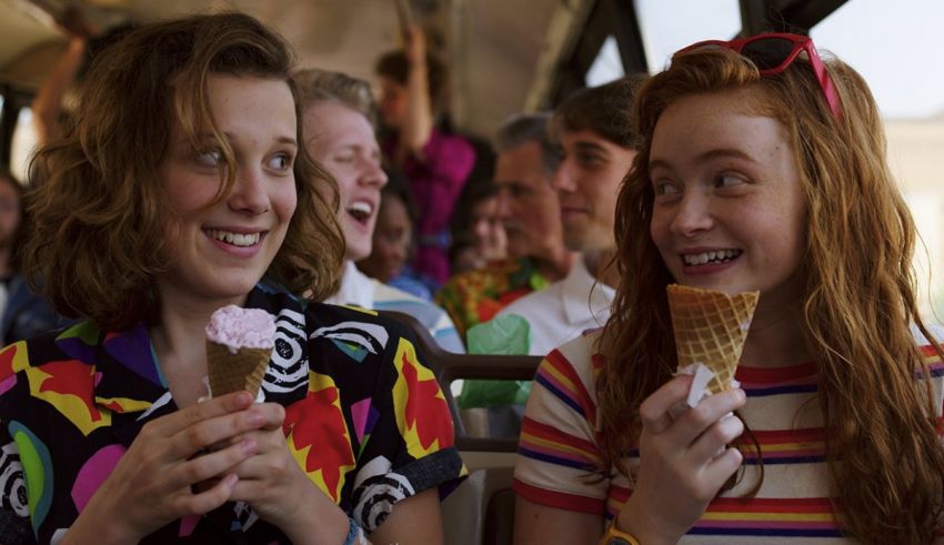 Two girls eating ice cream cones on a bus.