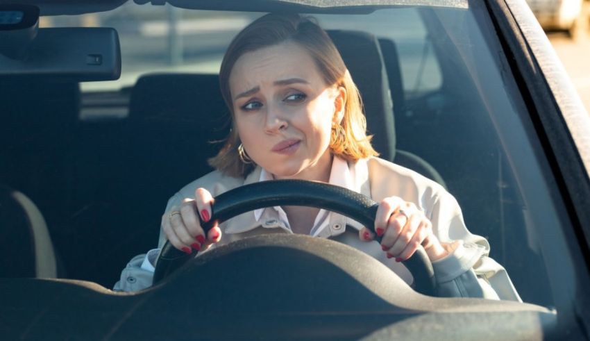 A woman driving a car with her hands on the steering wheel.