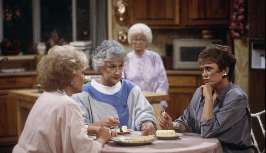 A group of women sitting around a table eating cake.