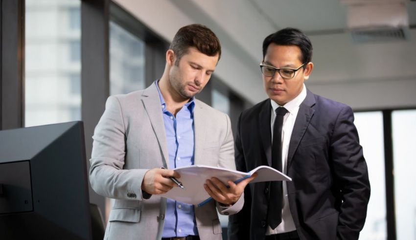 Two businessmen looking at a document in an office.