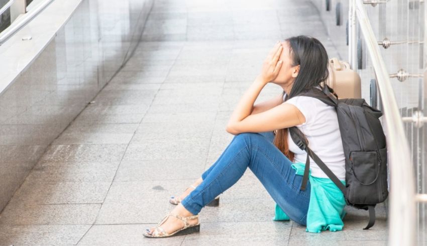 A young woman sitting on the steps of a train station.