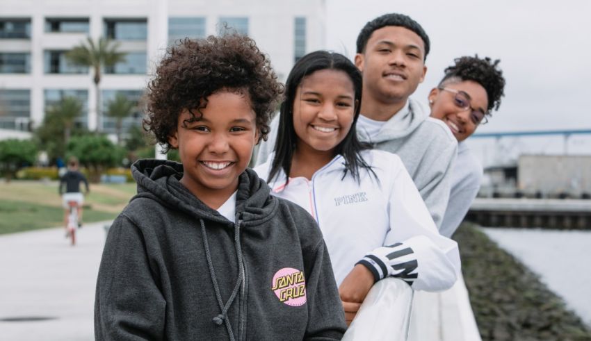 A group of young people posing for a photo by the water.