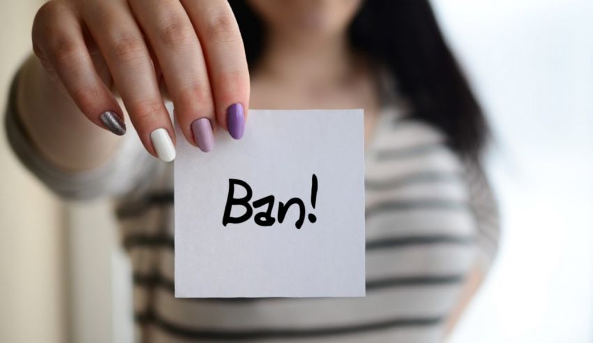 A woman holding up a piece of paper with the word ban.