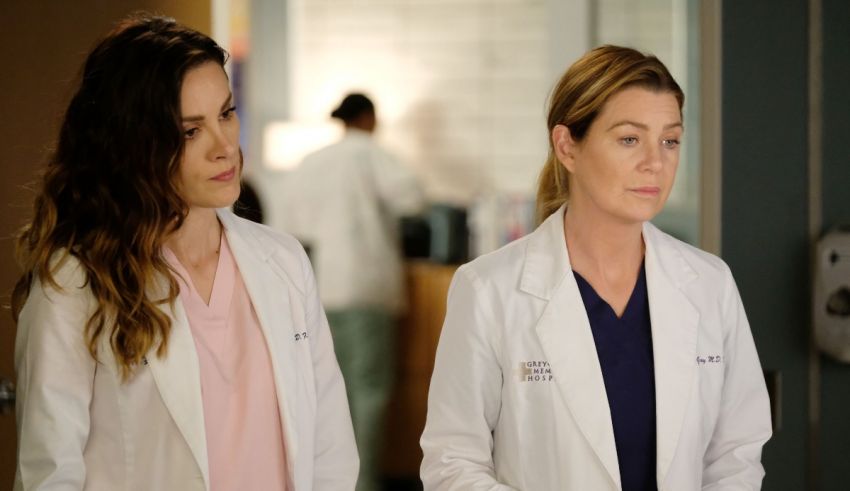 Two women in white lab coats standing next to each other.