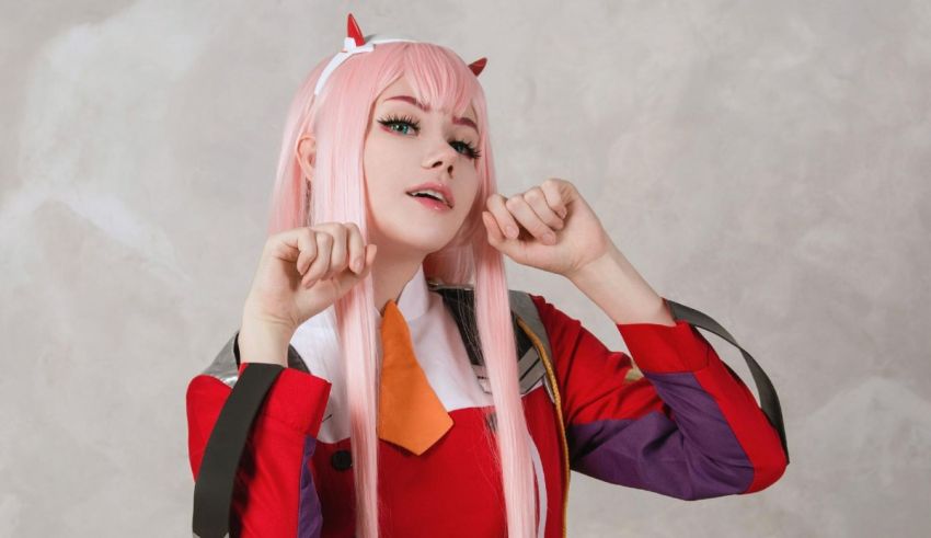 A girl with pink hair is posing for a photo.