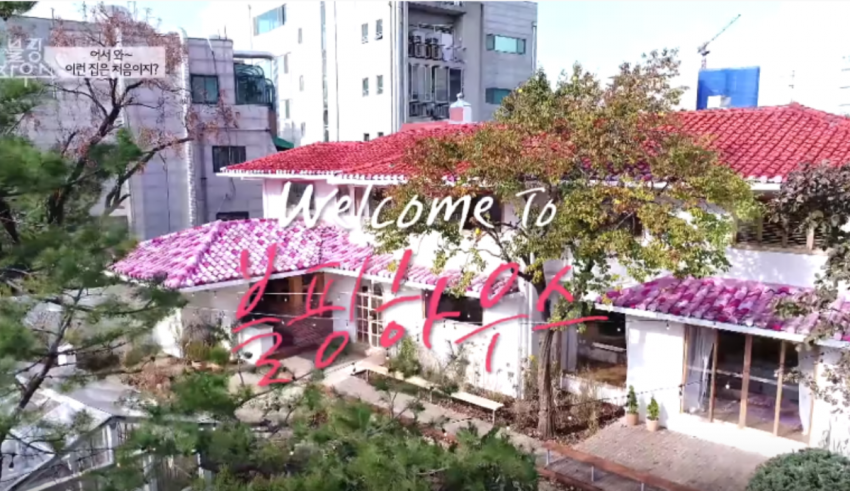 An aerial view of a house with pink flowers on the roof.