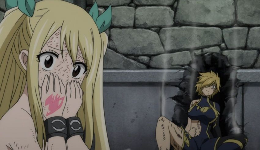 A girl with long blonde hair is sitting in front of a stone wall.