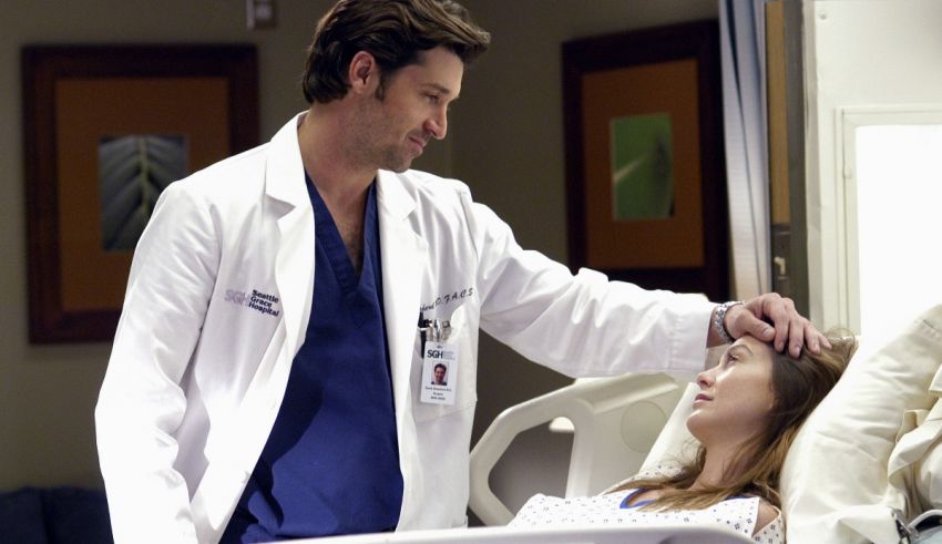 A man in a lab coat is touching a woman in a hospital bed.