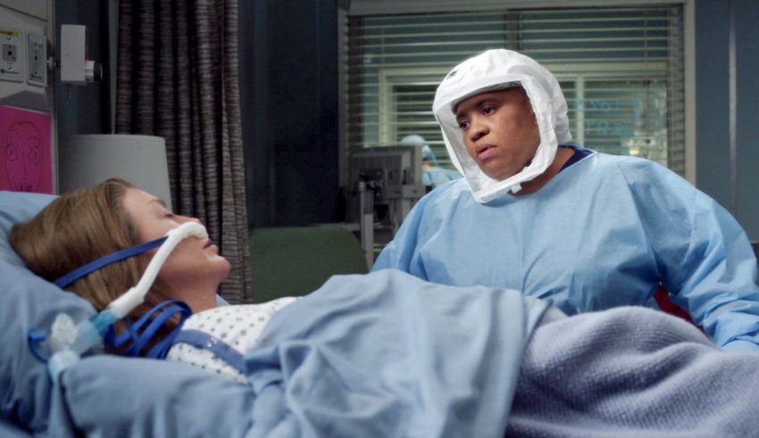 A woman in a hospital bed with a mask on her head.