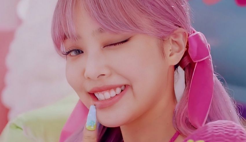 A girl with pink hair is smiling at the camera.