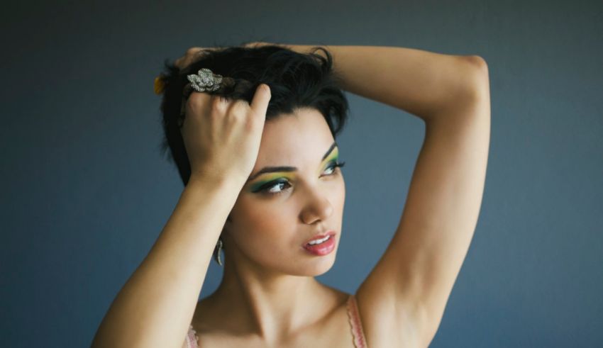 A woman posing with her hair in her hands.