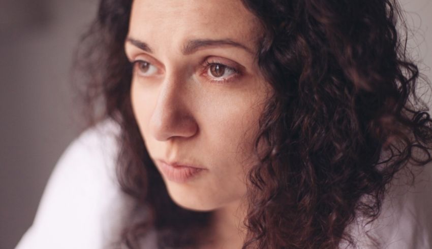 A woman with curly hair is staring at the camera.