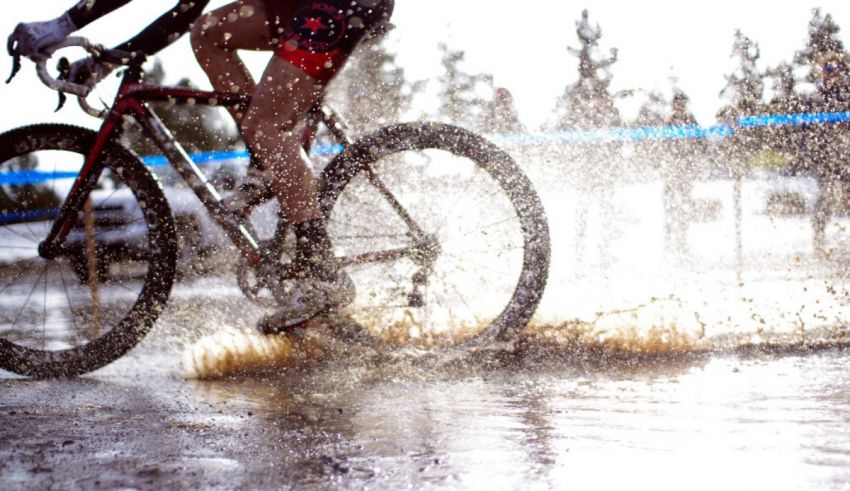 A person riding a bike through a puddle of water.