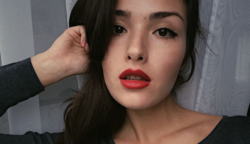 A woman with red lipstick is posing for a photo.