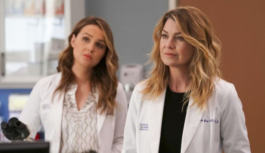 Two women in white lab coats standing next to each other.