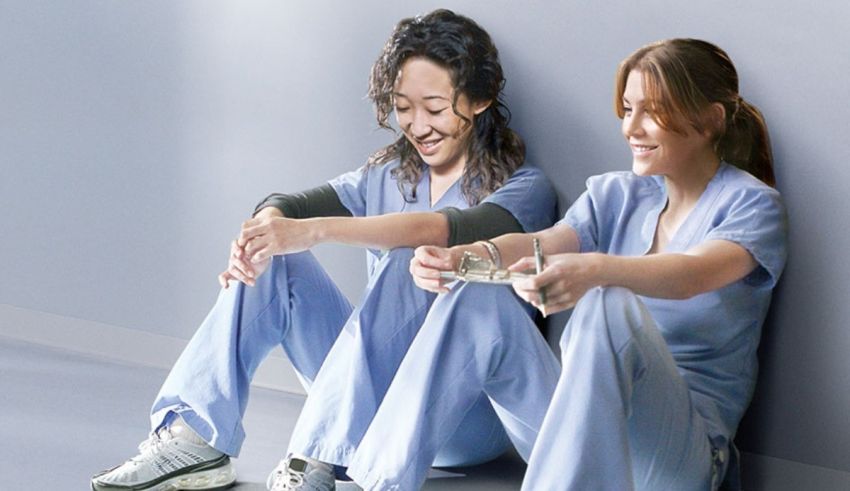Two women in scrubs sitting next to each other.
