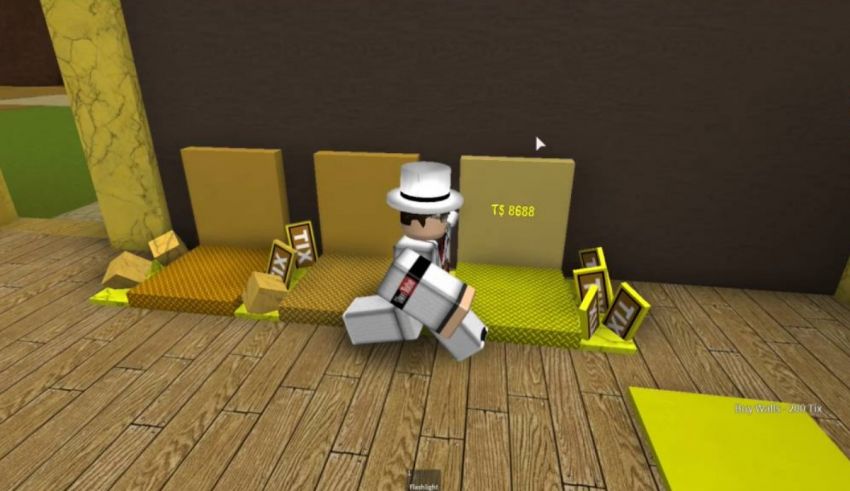 A man in a hat is standing on a wooden floor.