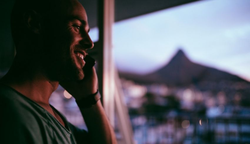 A man talking on a cell phone while looking out a window.