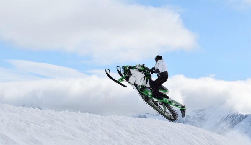 A person riding a snowmobile in the snow.