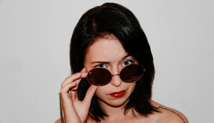 A woman wearing sunglasses and a tattoo.