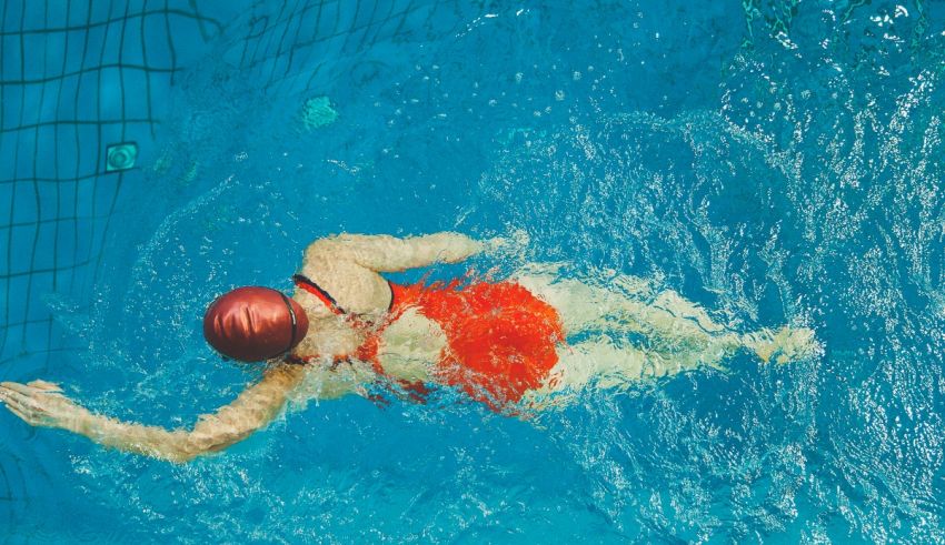 A woman in a red swimsuit swimming in a pool.