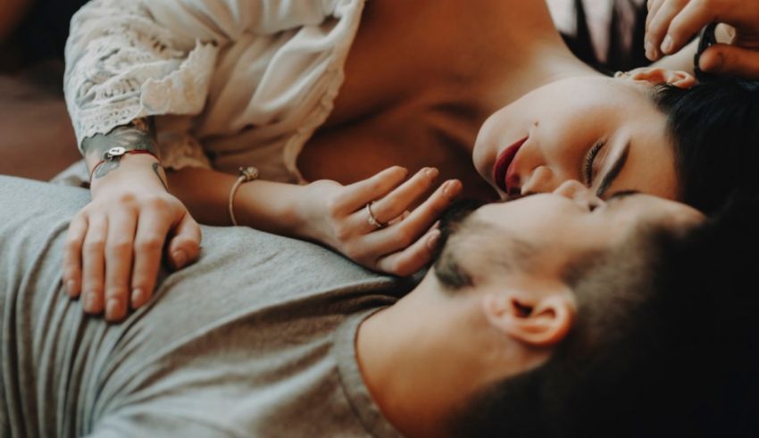 A man and woman laying on a bed with their eyes closed.
