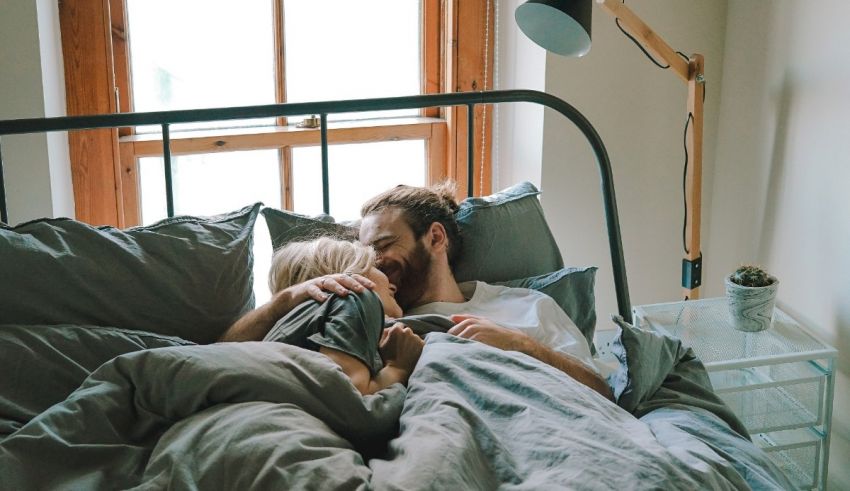 A man and woman embracing in bed.