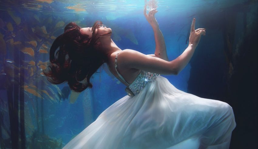A woman in a white dress underwater.