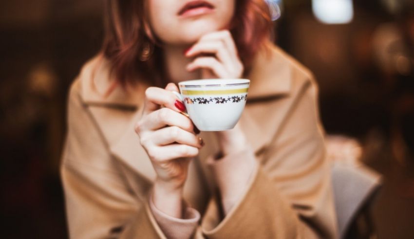 A woman with red hair holding a cup of coffee.