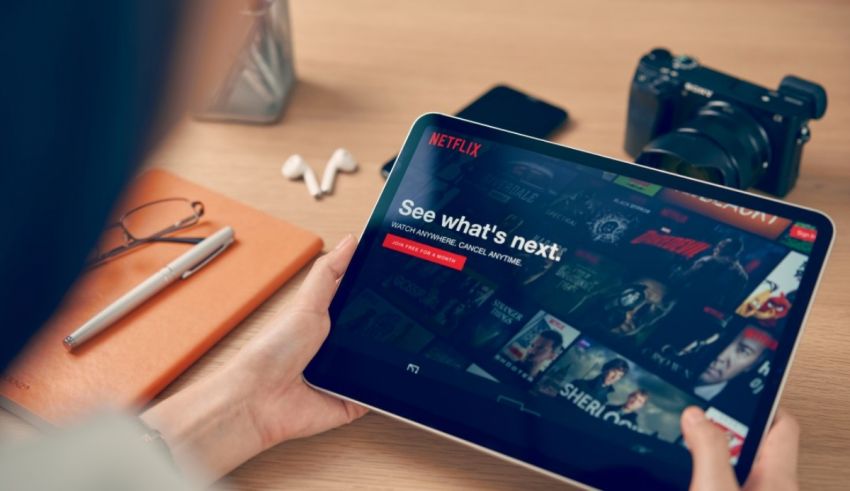 A person holding a tablet with netflix on it.
